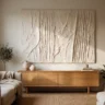 A large drywall-mud textured artwork with bold carved vertical ridges in warm white, hanging above a low oak sideboard