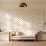 A luxury 3D plaster wall artwork with bold geometric chevron relief in warm white, hanging in an elegant entryway