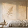 A wabi sabi plaster wall decor piece with soft limewash texture and a pressed dried fern accent, in a serene bedroom with linen bedding