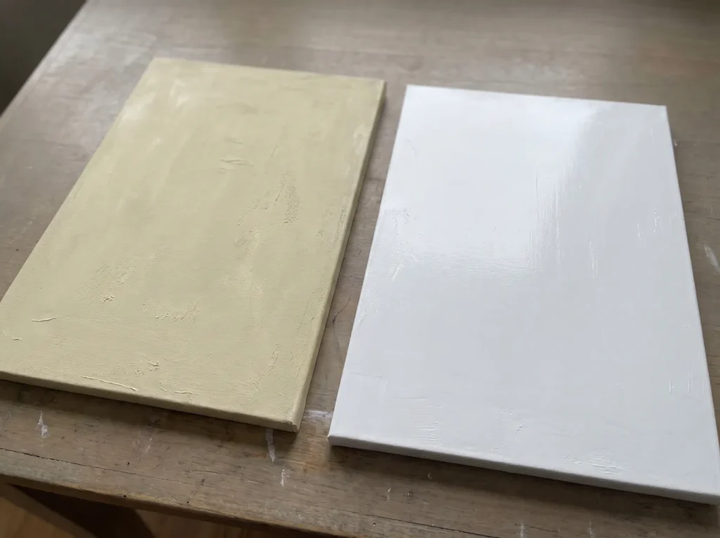 Yellowed joint compound canvas next to a bright white canvas made with archival modeling paste.